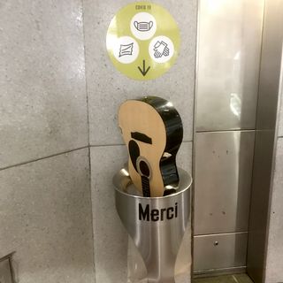 photo d'une guitare acoustique jetée dans une petite poubelle du métro à Paris.